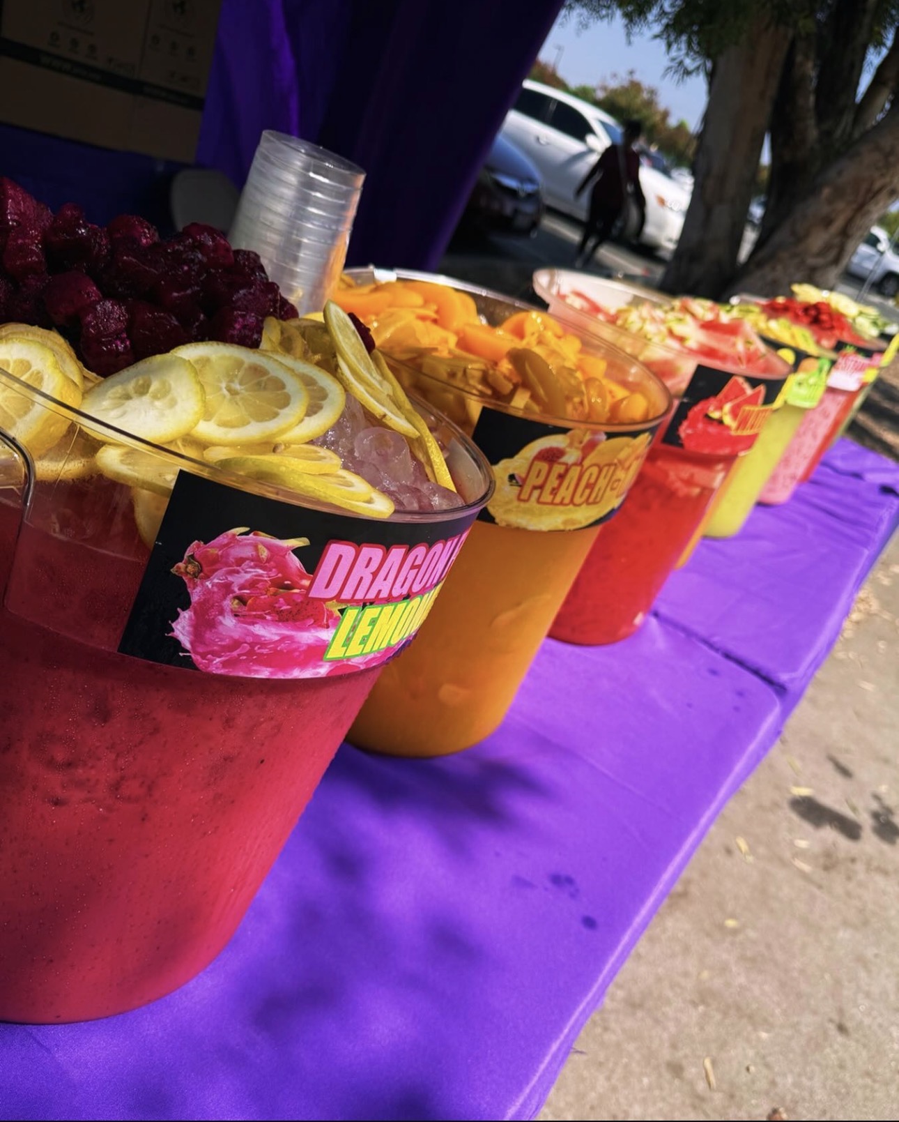 Colorful AguaFresca Queen drinks topped with fresh fruit at our purple booth table